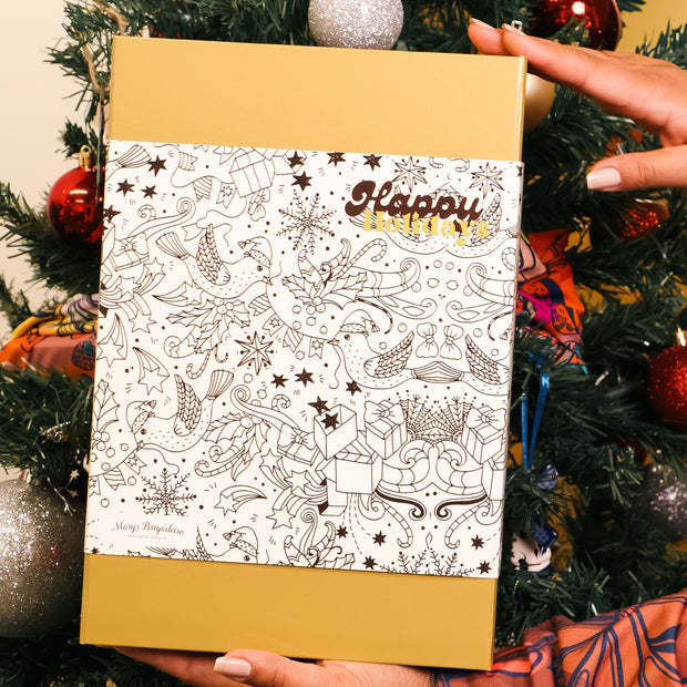 Person holding a gift box with 'Happy' text against a Christmas tree background