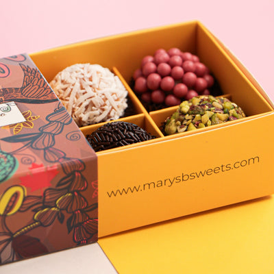 Box of assorted chocolates with a pink background and 'www.marysb sweets.com' branding.